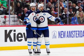 Mar 28, 2026; Denver, Colorado, USA; Winnipeg Jets left wing Kyle Connor (81) celebrates his empty net goal defenseman Dylan DeMelo (2) in the third period against the Colorado Avalanche at Ball Arena. Mandatory Credit: Ron Chenoy-Imagn Images