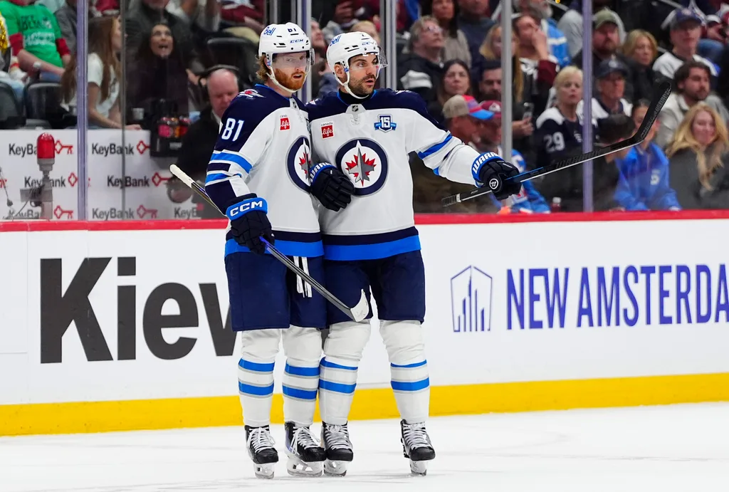 Mar 28, 2026; Denver, Colorado, USA; Winnipeg Jets left wing Kyle Connor (81) celebrates his empty net goal defenseman Dylan DeMelo (2) in the third period against the Colorado Avalanche at Ball Arena. Mandatory Credit: Ron Chenoy-Imagn Images