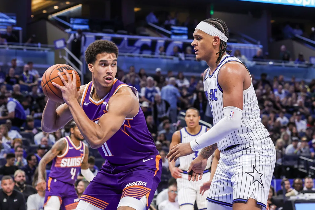 Mar 31, 2026; Orlando, Florida, USA; Phoenix Suns forward Oso Ighodaro (11) looks to pass in front of Orlando Magic forward Paolo Banchero (5) during the second half at Kia Center. Mandatory Credit: Mike Watters-Imagn Images