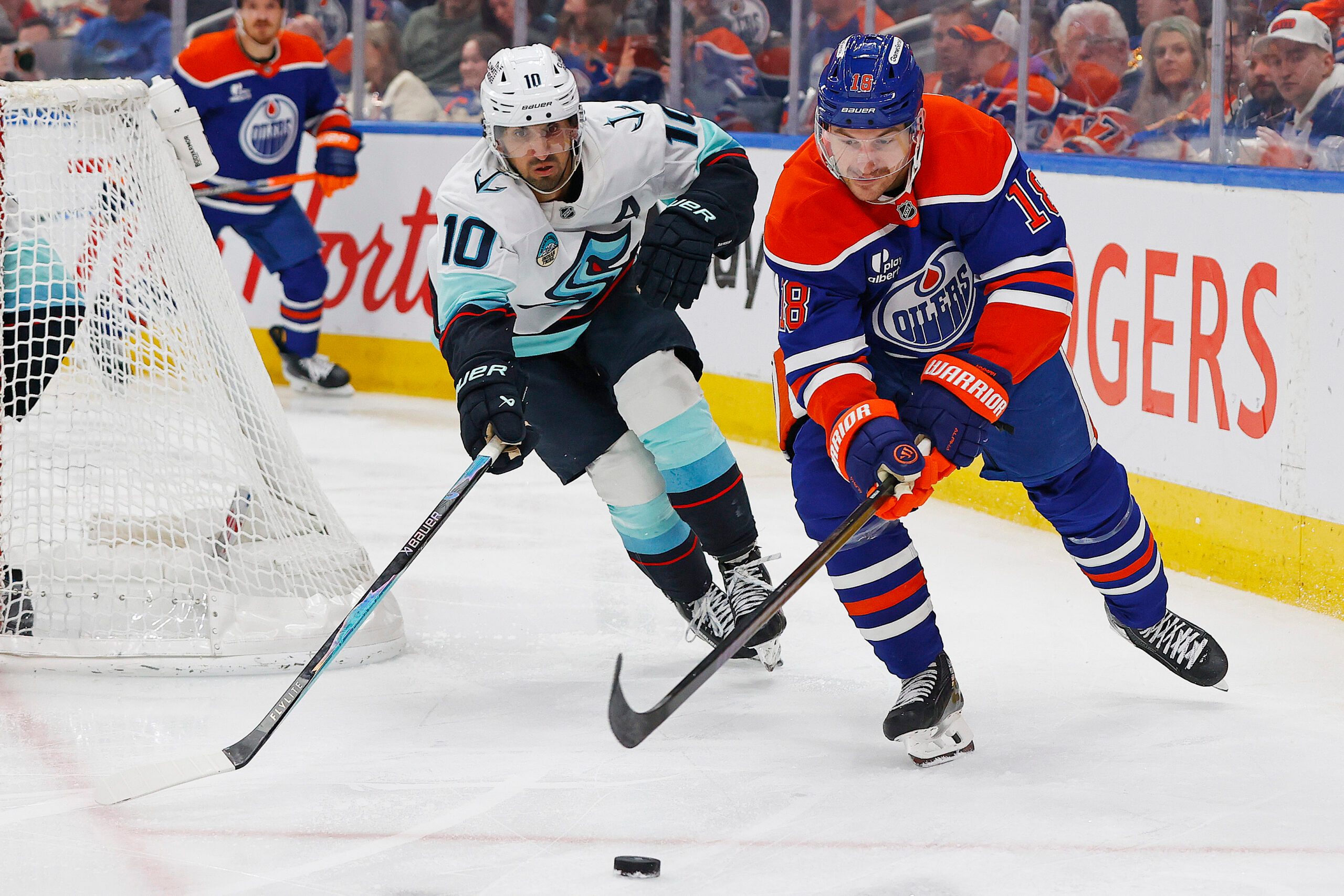 Mar 31, 2026; Edmonton, Alberta, CAN;  Edmonton Oilers forward Zach Hyman (18) and Seattle Kraken forward Matty Beniers (10) chase a loose puck during the third period at Rogers Place. Mandatory Credit: Perry Nelson-Imagn Images