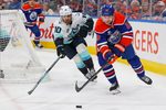 Mar 31, 2026; Edmonton, Alberta, CAN;  Edmonton Oilers forward Zach Hyman (18) and Seattle Kraken forward Matty Beniers (10) chase a loose puck during the third period at Rogers Place. Mandatory Credit: Perry Nelson-Imagn Images