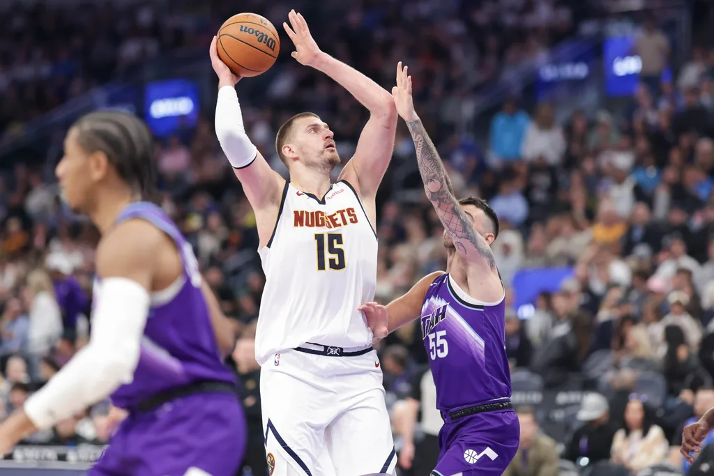 Apr 1, 2026; Salt Lake City, Utah, USA; Denver Nuggets center Nikola Jokić (15) shoots the ball over Utah Jazz guard John Konchar (55) during the second half at Delta Center. Mandatory Credit: Chris Nicoll-Imagn Images