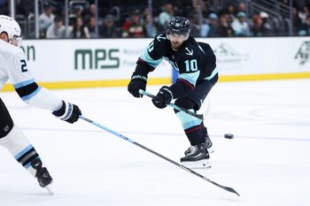 Apr 2, 2026; Seattle, Washington, USA; Seattle Kraken center Matty Beniers (10) passes while defended by Utah Mammoth defenseman Ian Cole (28) in the third period at Climate Pledge Arena. Mandatory Credit: Kevin Ng-Imagn Images