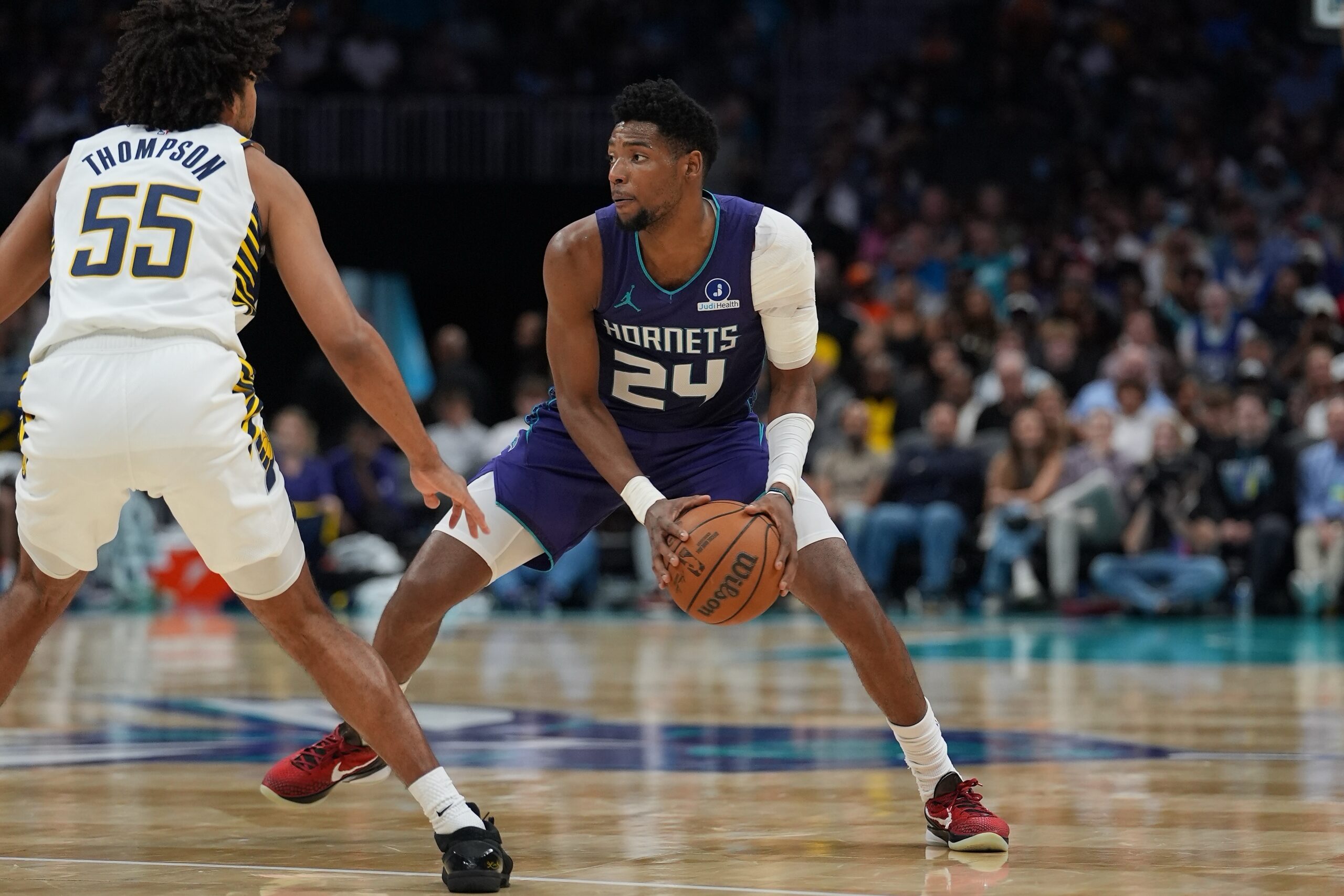 Apr 3, 2026; Charlotte, North Carolina, USA; Charlotte Hornets forward Brandon Miller (24) handles the ball defended by Indiana Pacers guard Ethan Thompson (55) during the second half at Spectrum Center. Mandatory Credit: Jim Dedmon-Imagn Images