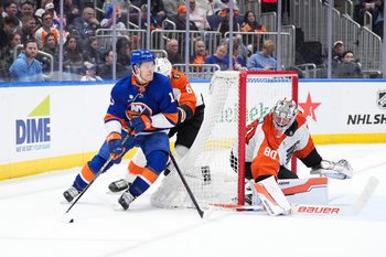 Apr 3, 2026; Elmont, New York, USA; New York Islanders forward Matthew Barzal (13) carries the puck past Philadelphia Flyers defenseman Travis Sanheim (6) and goaltender Dan Vladar (80) in the second period at UBS Arena. Mandatory Credit: Alexander Wohl-Imagn Images