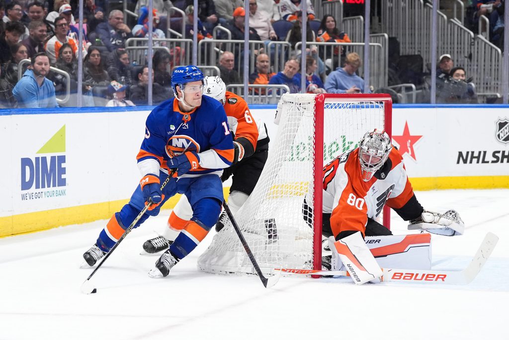Apr 3, 2026; Elmont, New York, USA; New York Islanders forward Matthew Barzal (13) carries the puck past Philadelphia Flyers defenseman Travis Sanheim (6) and goaltender Dan Vladar (80) in the second period at UBS Arena. Mandatory Credit: Alexander Wohl-Imagn Images