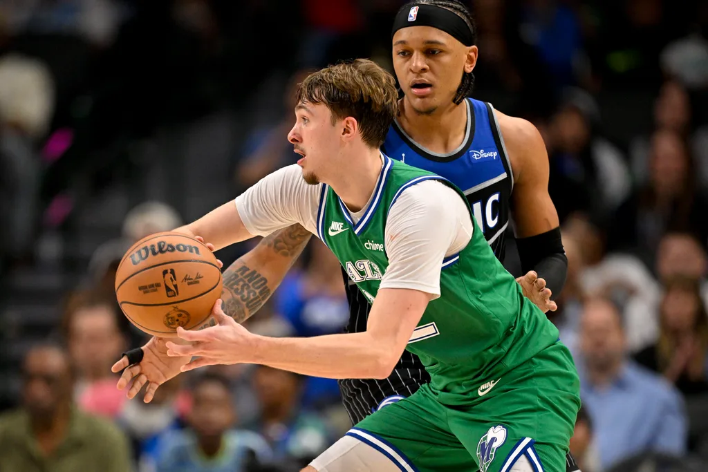 Apr 3, 2026; Dallas, Texas, USA; Dallas Mavericks forward Cooper Flagg (32) keeps the ball away from Orlando Magic forward Paolo Banchero (5) during the second half at the American Airlines Center. Mandatory Credit: Jerome Miron-Imagn Images