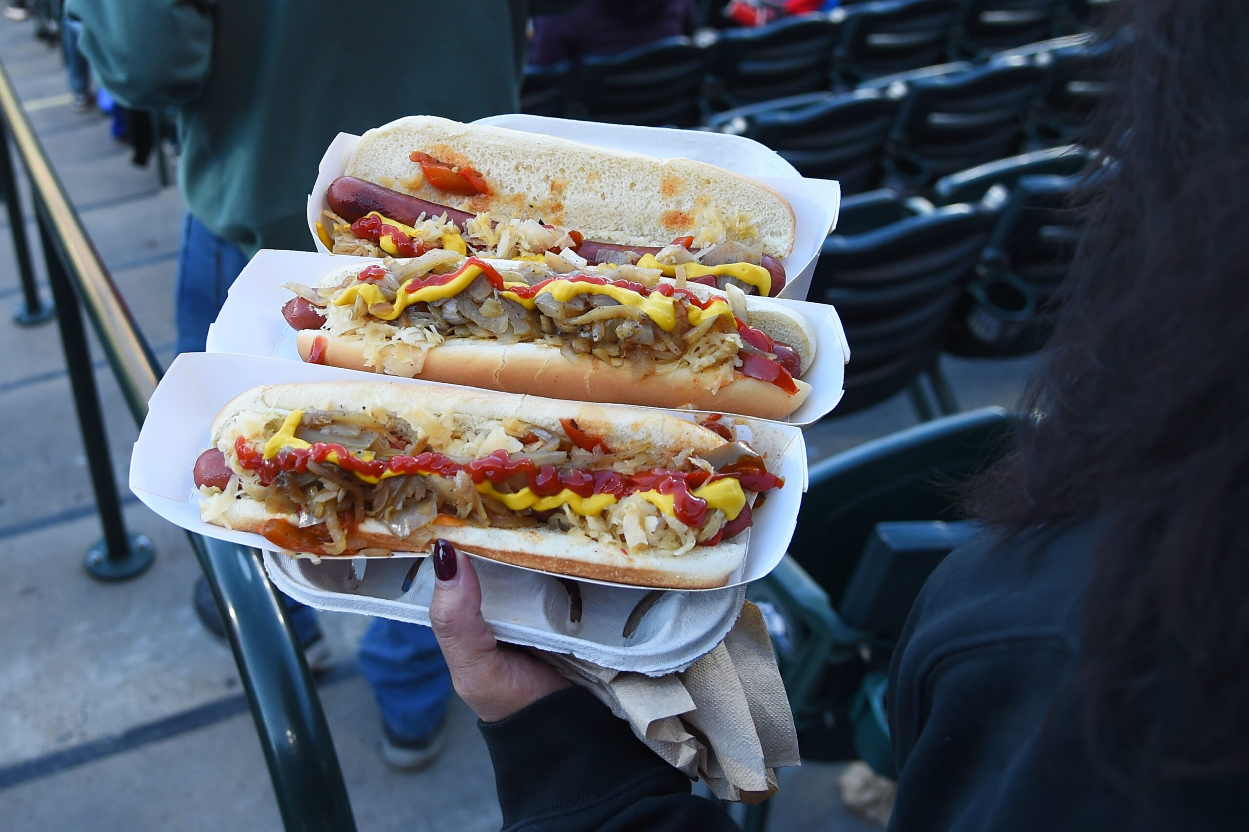 Apr 4, 2026; Denver, Colorado, USA; A fan carries hot dogs to her seat during the second inning between the Philadelphia Phillies and Colorado Rockies at Coors Field. Mandatory Credit: Christopher Hanewinckel-Imagn Images