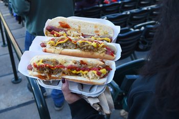 Apr 4, 2026; Denver, Colorado, USA; A fan carries hot dogs to her seat during the second inning between the Philadelphia Phillies and Colorado Rockies at Coors Field. Mandatory Credit: Christopher Hanewinckel-Imagn Images