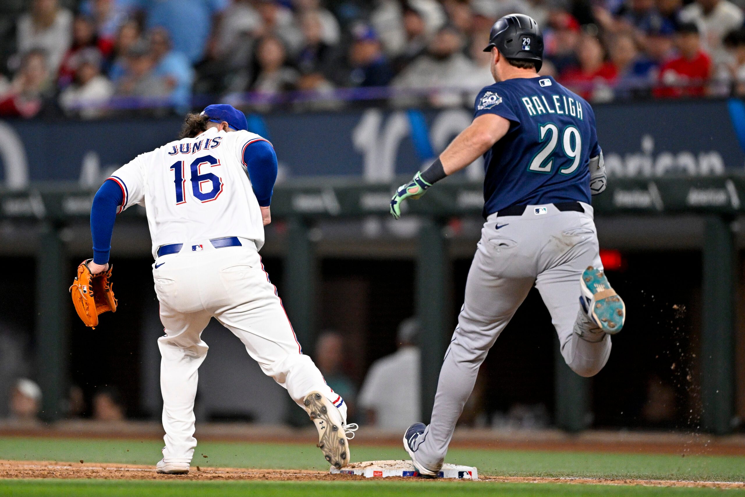 Apr 6, 2026; Arlington, Texas, USA; Texas Rangers relief pitcher Jakob Junis (16) puts out Seattle Mariners catcher Cal Raleigh (29) at first base during the ninth inning at Globe Life Field. Mandatory Credit: Jerome Miron-Imagn Images