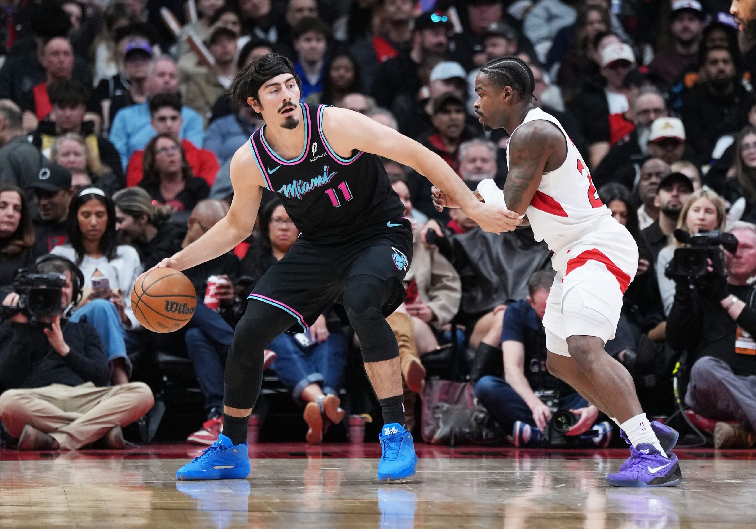 Apr 7, 2026; Toronto, Ontario, CAN; Miami Heat forward Jaime Jaquez Jr. (11) controls the ball as Toronto Raptors guard Jamal Shead (23) defends during the third quarter at Scotiabank Arena. Mandatory Credit: Nick Turchiaro-Imagn Images