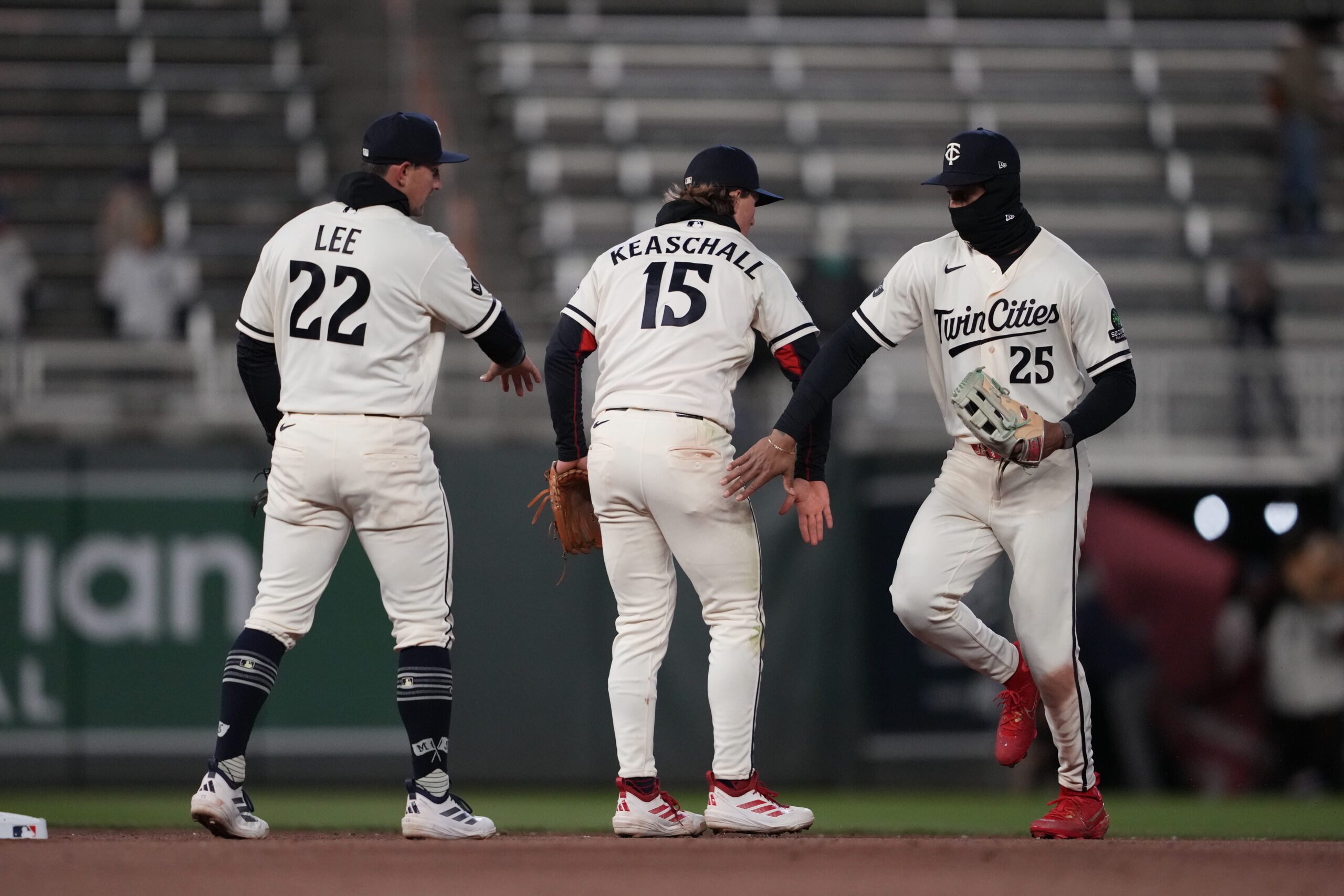 Apr 7, 2026; Minneapolis, Minnesota, USA; Minnesota Twins shortstop Brooks Lee (22) second baseman Luke Keaschall (15) and center fielder Byron Buxton (25) celebrate after defeating the Detroit Tigers at Target Field. Mandatory Credit: Jordan Johnson-Imagn Images