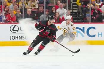 Apr 7, 2026; Raleigh, North Carolina, USA;  Carolina Hurricanes center Sebastian Aho (20) skates with the puck against Boston Bruins defenseman Charlie McAvoy (73) during the third period at Lenovo Center. Mandatory Credit: James Guillory-Imagn Images