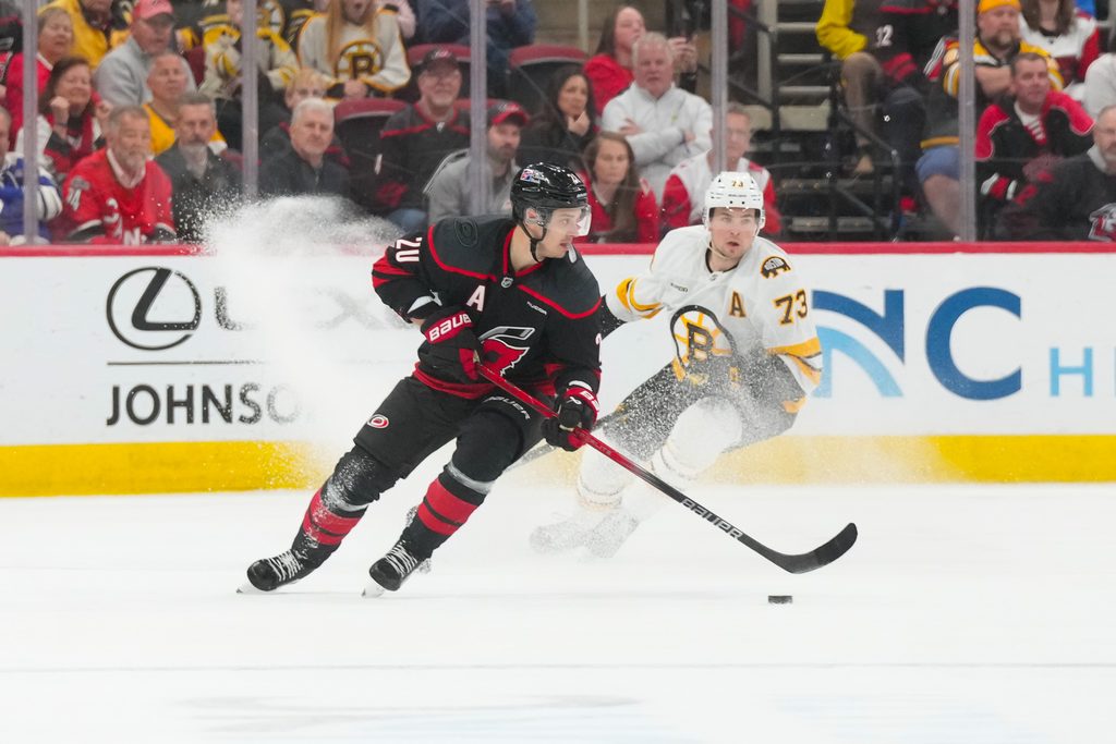 Apr 7, 2026; Raleigh, North Carolina, USA; Carolina Hurricanes center Sebastian Aho (20) skates with the puck against Boston Bruins defenseman Charlie McAvoy (73) during the third period at Lenovo Center. Mandatory Credit: James Guillory-Imagn Images