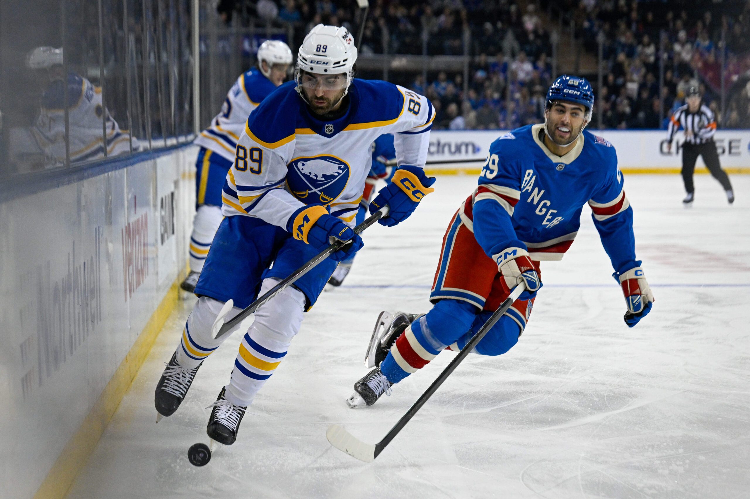 Apr 8, 2026; New York, New York, USA; Buffalo Sabres right wing Alex Tuch (89) attempts to control the puck defended by New York Rangers defenseman Matthew Robertson (29) during the first period at Madison Square Garden. Mandatory Credit: Dennis Schneidler-Imagn Images