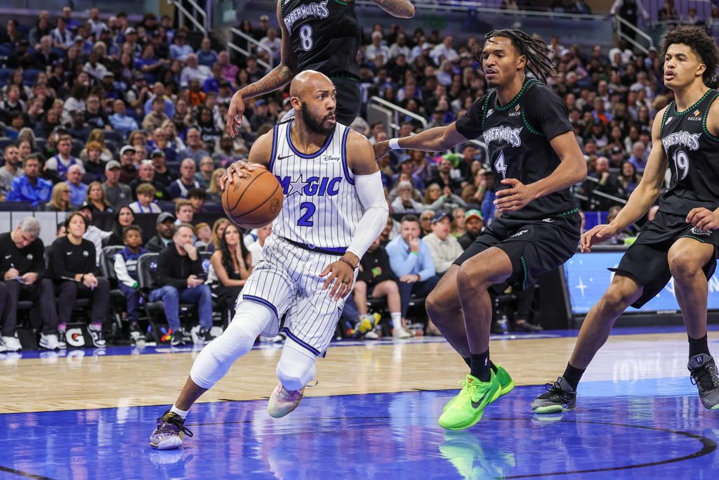 Apr 8, 2026; Orlando, Florida, USA; Orlando Magic guard Jevon Carter (2) drives around Minnesota Timberwolves forward Julian Phillips (4) during the second half at Kia Center. Mandatory Credit: Mike Watters-Imagn Images