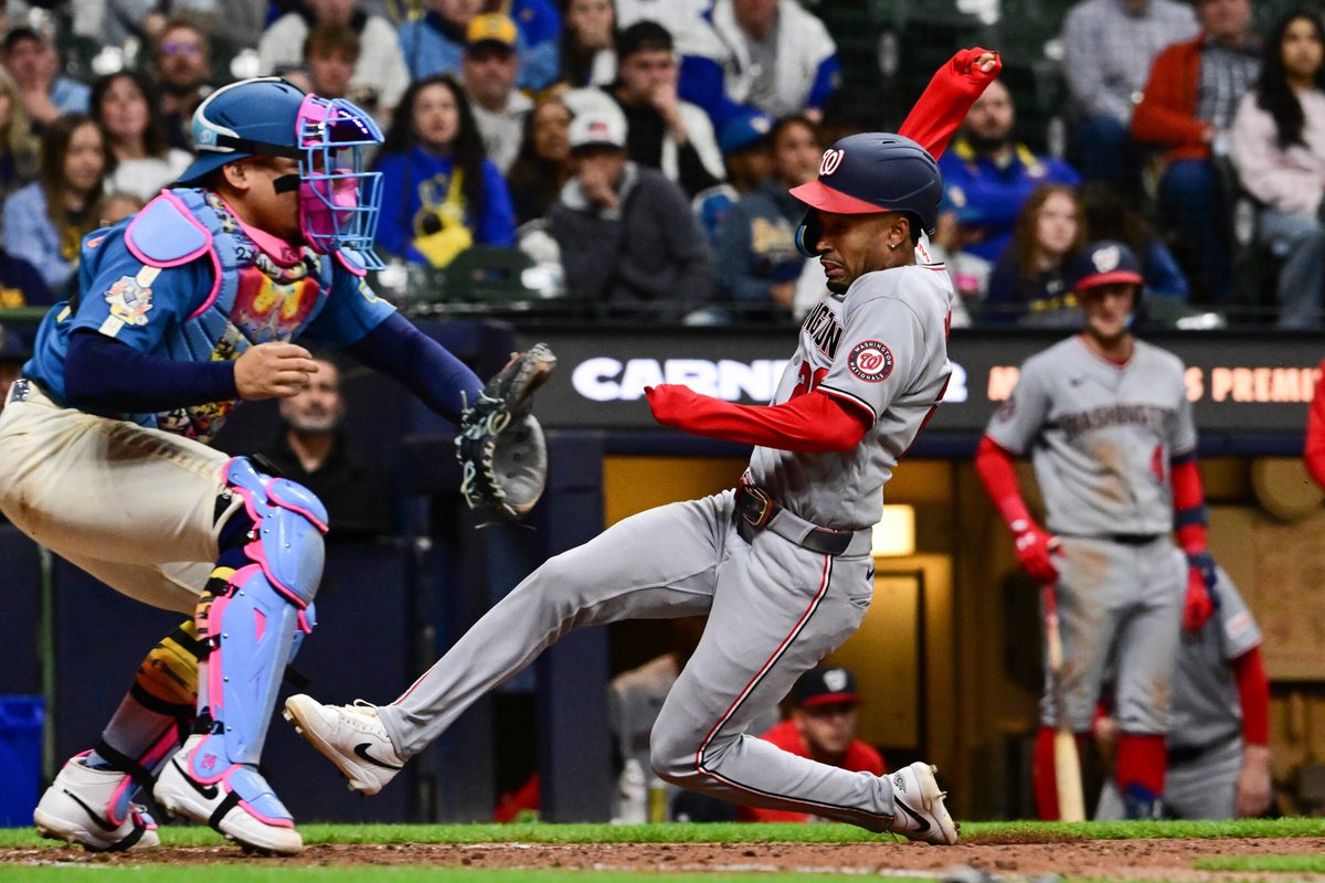 Apr 10, 2026; Milwaukee, Wisconsin, USA; Washington Nationals shortstop Nasim Nunez (26) scores on a squeeze bunt as Milwaukee Brewers catcher William Contreras (24) waits for the ball in the ninth inning at American Family Field. Mandatory Credit: Benny Sieu-Imagn Images