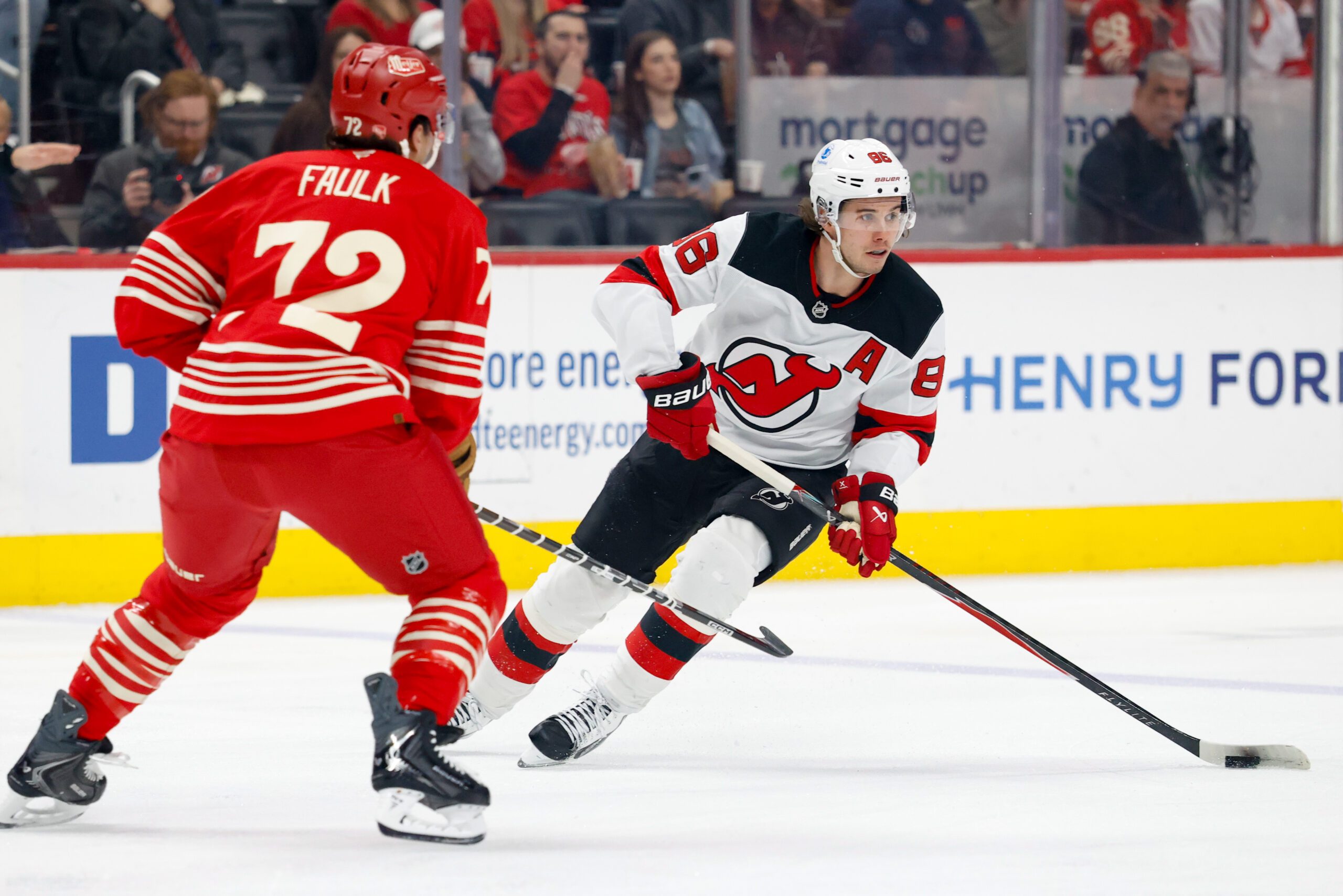 Apr 11, 2026; Detroit, Michigan, USA;  New Jersey Devils center Jack Hughes (86) skates with the puck defended by Detroit Red Wings defenseman Justin Faulk (72) in the first period at Little Caesars Arena. Mandatory Credit: Rick Osentoski-Imagn Images