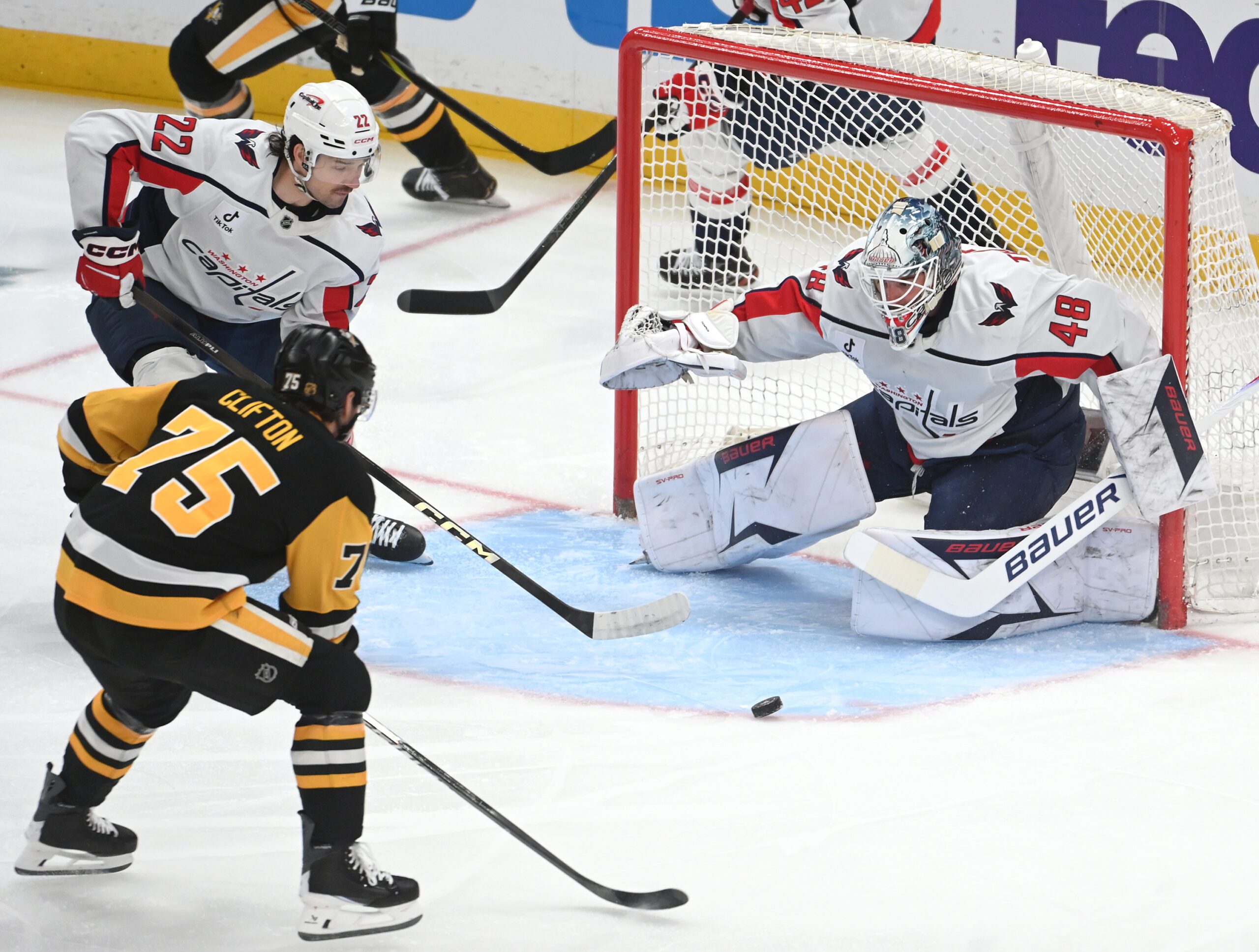 Apr 11, 2026; Pittsburgh, Pennsylvania, USA;  Pittsburgh Penguins defenseman Connor Clifton (75) pressures Washington Capitals goalie Logan Thompson (48) as left wing Brandon Duhaime (22) takes part in the play during the first period at PPG Paints Arena. Mandatory Credit: Philip G. Pavely-Imagn Images