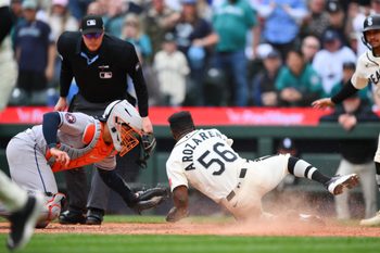 Apr 12, 2026; Seattle, Washington, USA; Seattle Mariners left fielder Randy Arozarena (56) avoids a tag by Houston Astros catcher Yainer Diaz (21) to score a run during the sixth inning at T-Mobile Park. Mandatory Credit: Steven Bisig-Imagn Images