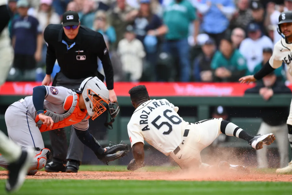 Apr 12, 2026; Seattle, Washington, USA; Seattle Mariners left fielder Randy Arozarena (56) avoids a tag by Houston Astros catcher Yainer Diaz (21) to score a run during the sixth inning at T-Mobile Park. Mandatory Credit: Steven Bisig-Imagn Images