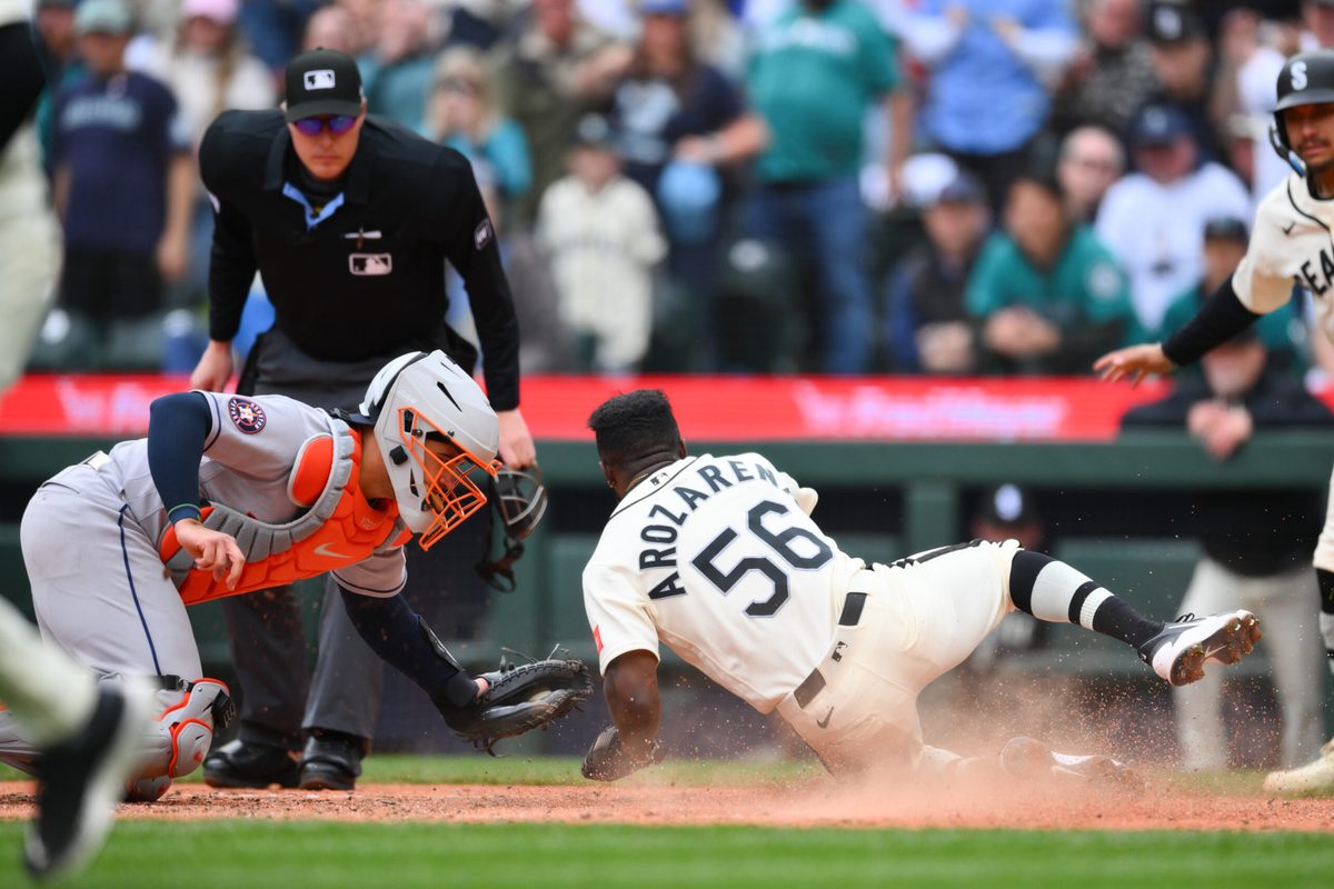 Apr 12, 2026; Seattle, Washington, USA; Seattle Mariners left fielder Randy Arozarena (56) avoids a tag by Houston Astros catcher Yainer Diaz (21) to score a run during the sixth inning at T-Mobile Park. Mandatory Credit: Steven Bisig-Imagn Images