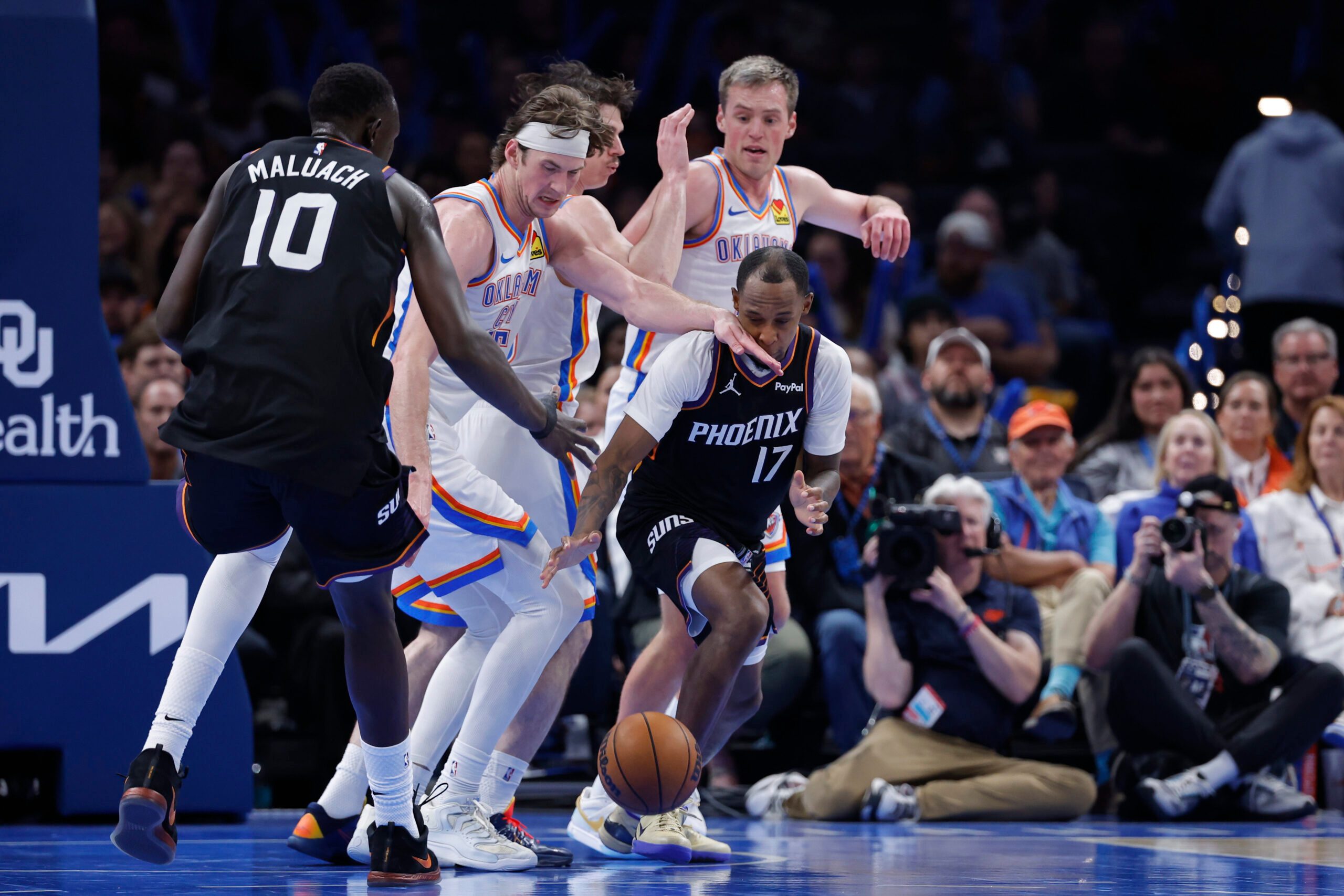 Apr 12, 2026; Oklahoma City, Oklahoma, USA; Phoenix Suns guard Jamaree Bouyea (17) and Oklahoma City Thunder center Branden Carlson (15) reach for a loose ball during the second half at Paycom Center. Mandatory Credit: Alonzo Adams-Imagn Images