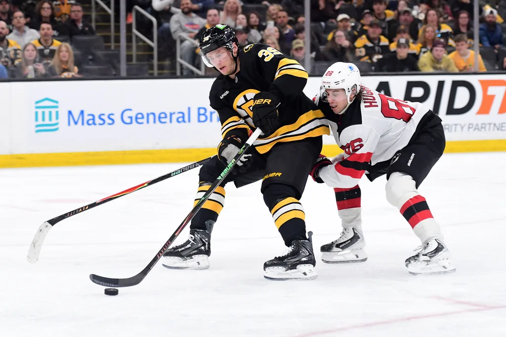 Apr 14, 2026; Boston, Massachusetts, USA; Boston Bruins center Morgan Geekie (39) controls the puck against New Jersey Devils center Jack Hughes (86) during the third period at TD Garden. Mandatory Credit: Bob DeChiara-Imagn Images