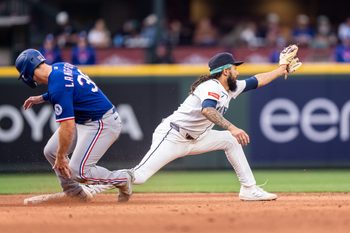 Apr 18, 2026; Seattle, Washington, USA; Texas Rangers left fielder Wyatt Langford (36) slides safely into second base ahead of a throw to Seattle Mariners shortstop J.P. Crawford (3) during the ninth inning at T-Mobile Park. Mandatory Credit: Stephen Brashear-Imagn Images