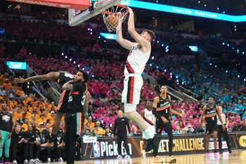 Apr 19, 2026; San Antonio, Texas, USA; Portland Trail Blazers center Donovan Clingan (23) dunks over San Antonio Spurs forward Julian Champagnie (30) during the second half of game one of the first round of the 2026 NBA Playoffs at Frost Bank Center. Mandatory Credit: Scott Wachter-Imagn Images