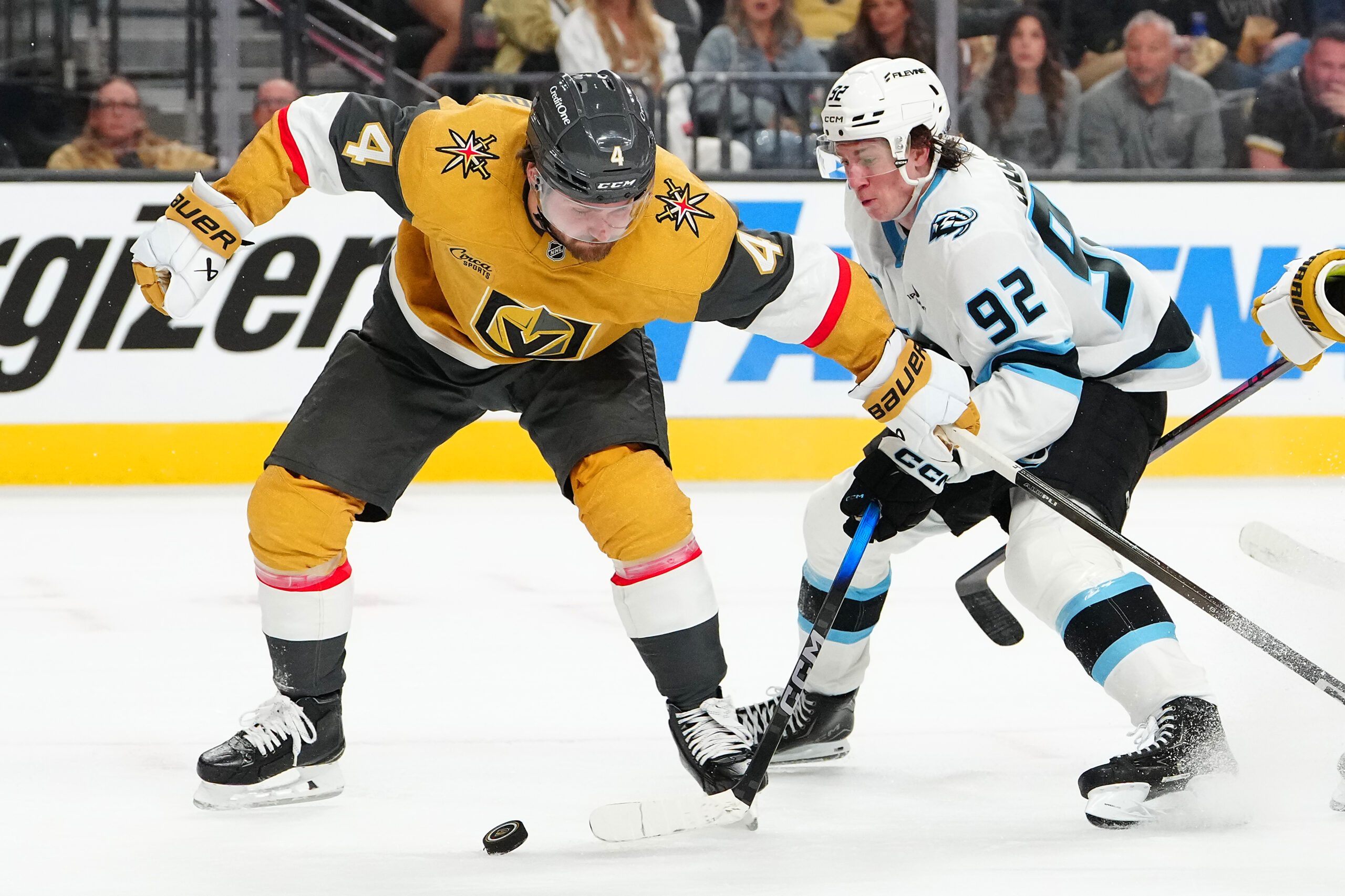 Apr 19, 2026; Las Vegas, Nevada, USA; Utah Mammoth center Logan Cooley (92) slips the puck around Vegas Golden Knights defenseman Rasmus Andersson (4) during the second period of game one of the first round of the 2026 Stanley Cup Playoffs at T-Mobile Arena. Mandatory Credit: Stephen R. Sylvanie-Imagn Images
