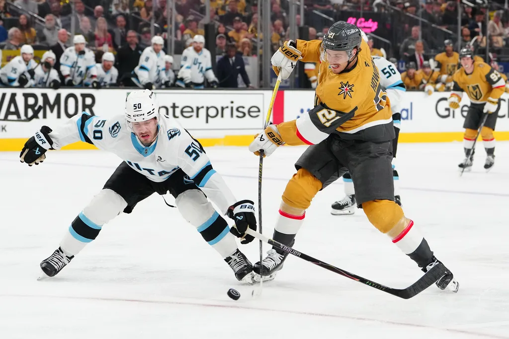 Apr 21, 2026; Las Vegas, Nevada, USA; Utah Mammoth defenseman Sean Durzi (50) attempts to deflect a shot attempt by Vegas Golden Knights center Brett Howden (21) during the first period of game two of the first round of the 2026 Stanley Cup Playoffs at T-Mobile Arena. Mandatory Credit: Stephen R. Sylvanie-Imagn Images
