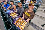 Apr 21, 2026; Denver, Colorado, USA; Colorado Rockies and San Diego Padres fans with the 999 challenge hot dog and beer food during the game at Coors Field. Mandatory Credit: Ron Chenoy-Imagn Images