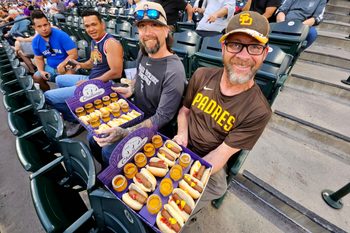 Apr 21, 2026; Denver, Colorado, USA; Colorado Rockies and San Diego Padres fans with the 999 challenge hot dog and beer food during the game at Coors Field. Mandatory Credit: Ron Chenoy-Imagn Images