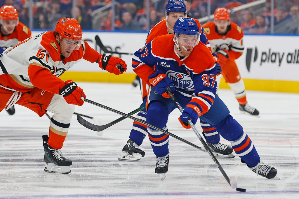 Apr 22, 2026; Edmonton, Alberta, CAN; Anaheim Ducks forward Cutter Gauthier (61) tries to knock the puck away from Edmonton Oilers forward Connor McDavid (97) during the first period in game two of the first round of the 2026 Stanley Cup Playoffs at Rogers Place. Mandatory Credit: Perry Nelson-Imagn Images