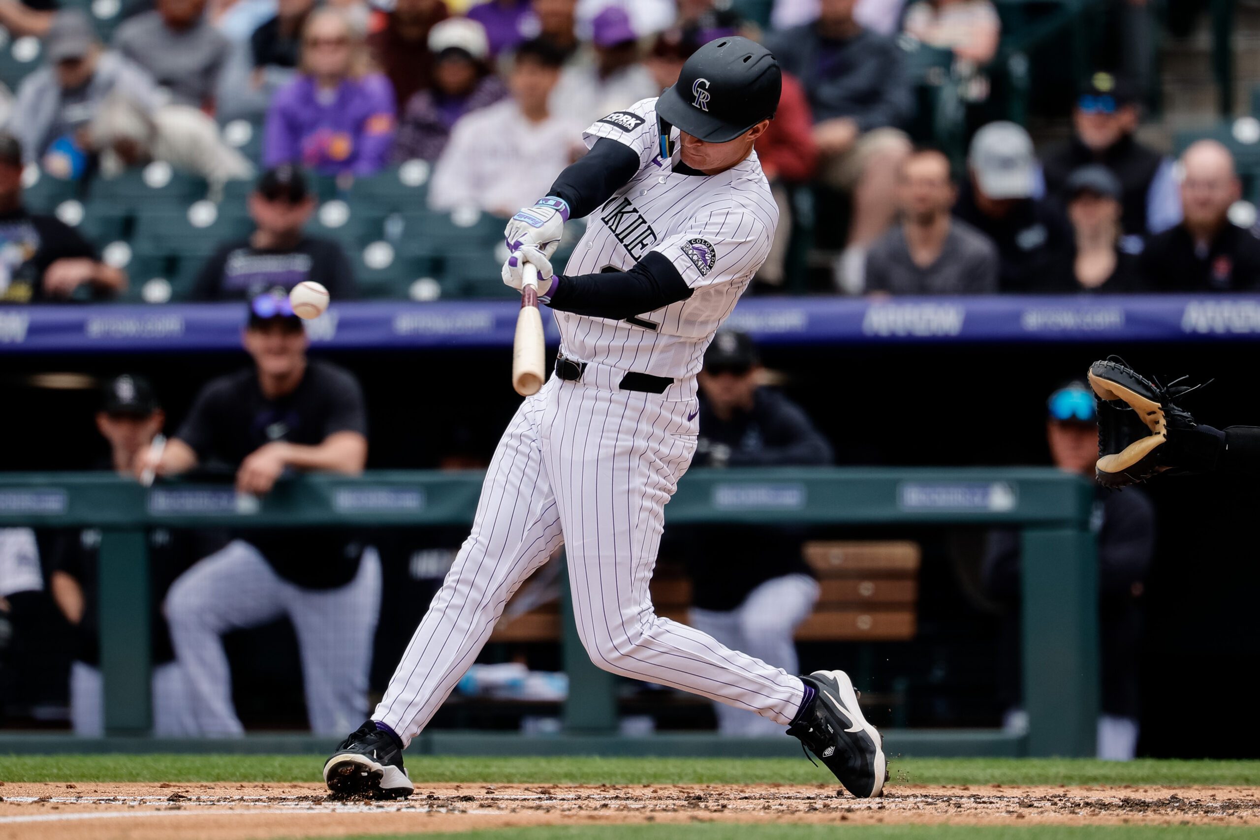 Apr 23, 2026; Denver, Colorado, USA; Colorado Rockies left fielder Mickey Moniak (22) hits a single in the second inning against the San Diego Padres at Coors Field. Mandatory Credit: Isaiah J. Downing-Imagn Images