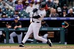 Apr 23, 2026; Denver, Colorado, USA; Colorado Rockies left fielder Mickey Moniak (22) hits a single in the second inning against the San Diego Padres at Coors Field. Mandatory Credit: Isaiah J. Downing-Imagn Images