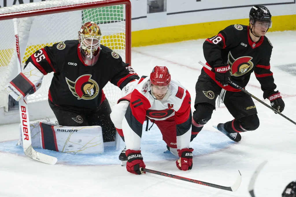 Apr 23, 2026; Ottawa, Ontario, CAN; Carolina Hurricanes center Jordan Staal (11) is taken to the ice by Ottawa Senators center Tim Stutzle (18) in the third period of game three of the first round of the 2026 Stanley Cup Playoffs at the Canadian Tire Centre. Mandatory Credit: Marc DesRosiers-Imagn