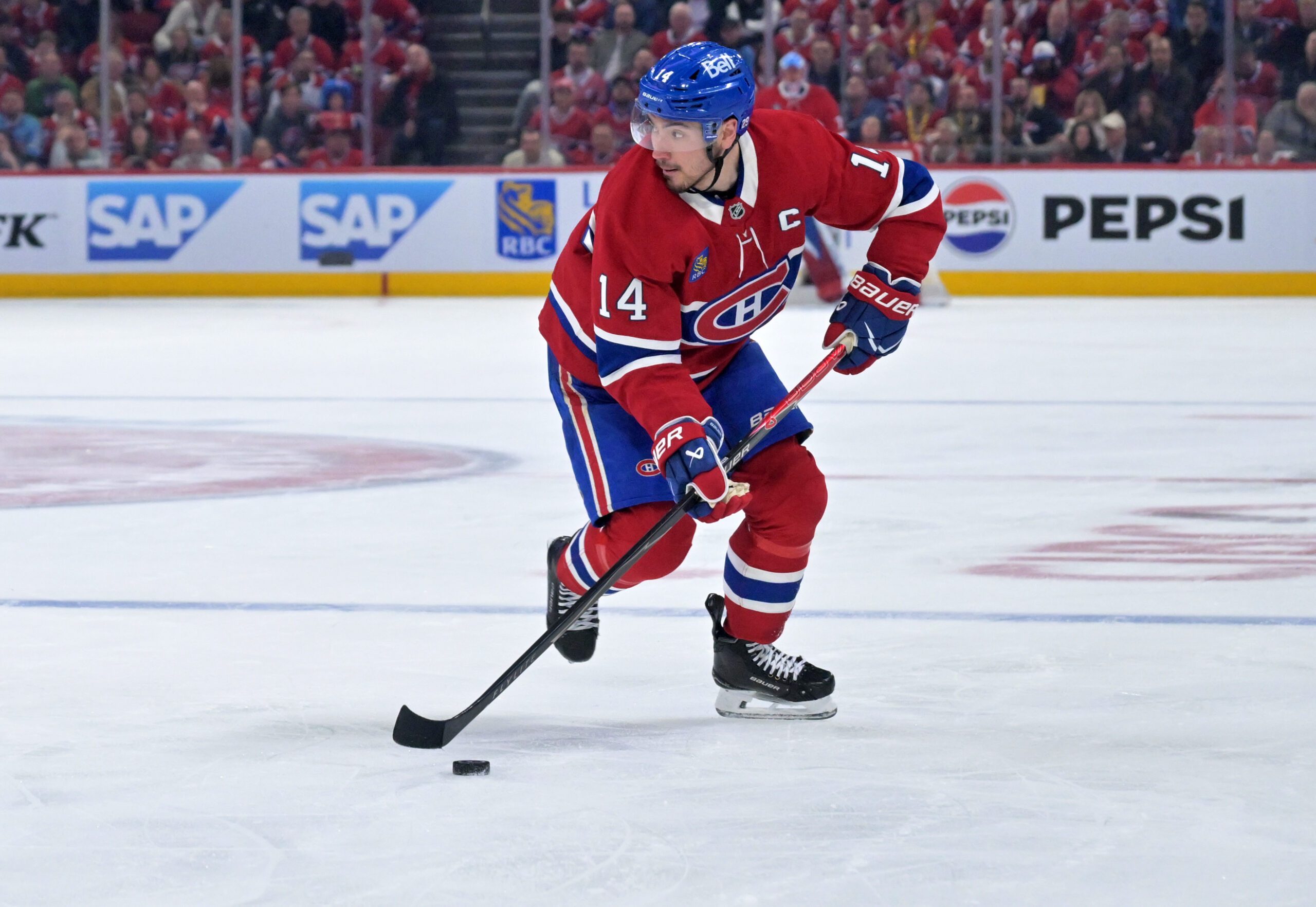 Apr 24, 2026; Montreal, Quebec, CAN; Montreal Canadiens forward Nick Suzuki (14) plays the puck against the Tampa Bay Lightning during the third period in game three of the first round of the 2026 Stanley Cup Playoffs at the Bell Centre. Mandatory Credit: Eric Bolte-Imagn Images