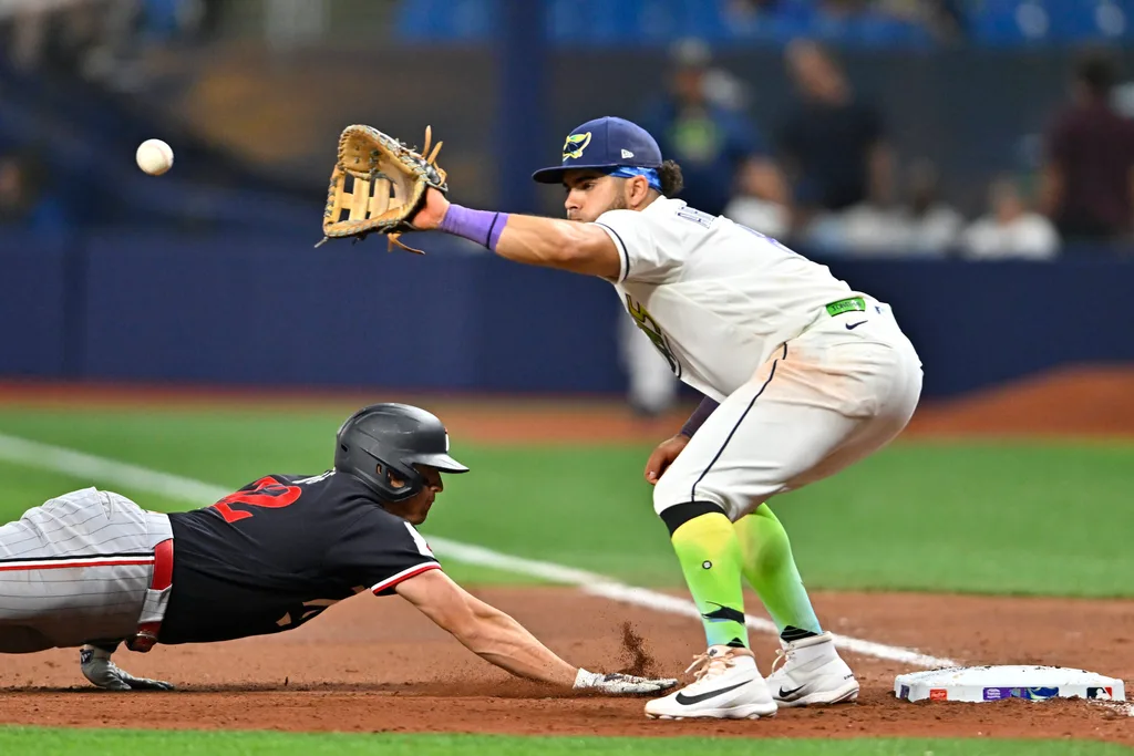 Apr 24, 2026; St. Petersburg, Florida, USA; Minnesota Twins infielder Brooks Lee (22) slides to first base during the seventh inning against Tampa Bay Rays infielder Jonathan Aranda (8) at Tropicana Field. Mandatory Credit: Pablo Robles-Imagn Images