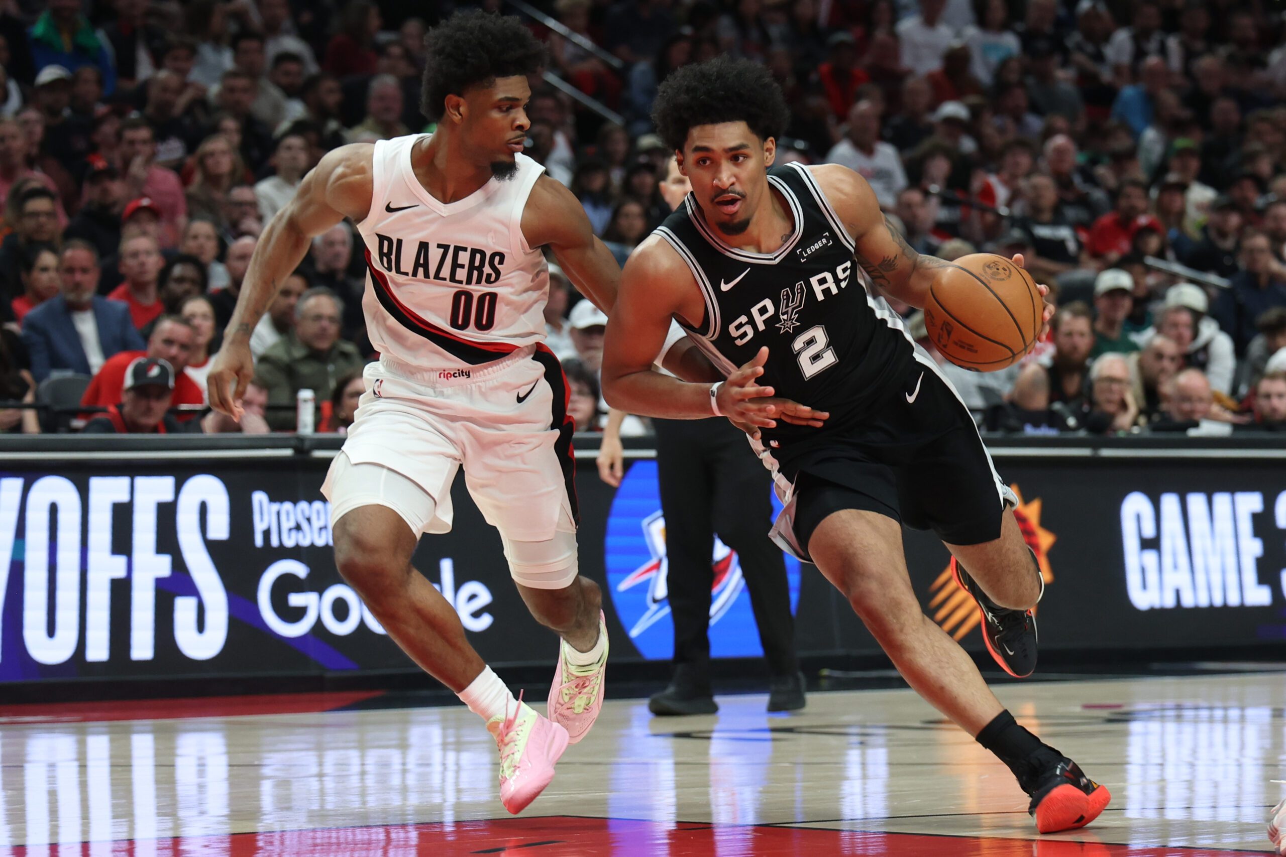 Apr 24, 2026; Portland, Oregon, USA; San Antonio Spurs guard Dylan Harper (2) drives to the basket past Portland Trail Blazers guard Scoot Henderson (00) during the second half during game three of the first round of the 2026 NBA Playoffs at Moda Center. Mandatory Credit: Jaime Valdez-Imagn Images