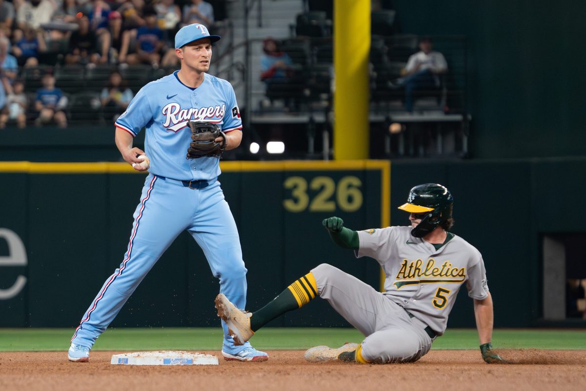 Apr 26, 2026; Arlington, Texas, USA; Texas Rangers shortstop Corey Seager (5) forces Athletics shortstop Jacob Wilson (5) out at second base during the fourth inning at Globe Life Field. Mandatory Credit: Raymond Carlin III-Imagn Images