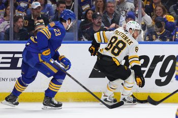 Apr 28, 2026; Buffalo, New York, USA; Boston Bruins right wing David Pastrnak (88) controls the puck as Buffalo Sabres defenseman Mattias Samuelsson (23) defends during the third period in game five of the first round of the 2026 Stanley Cup Playoffs at KeyBank Center. Mandatory Credit: Timothy T. Ludwig-Imagn Images