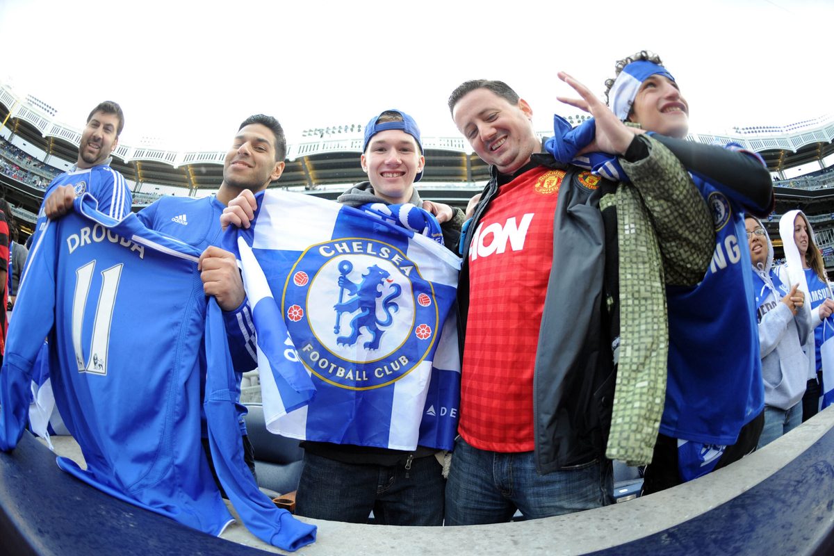 May 25, 2013; Bronx, NY, USA; A Manchester United fan (red) cheers with Chelsea fans before the first half against Manchester City at Yankee Stadium. Manchester City won 5-3. Mandatory Credit: Joe Camporeale-Imagn Images