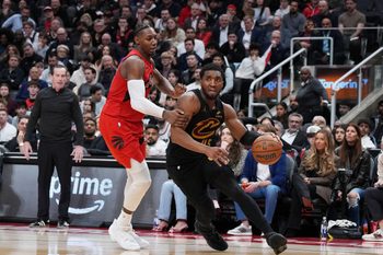 May 1, 2026; Toronto, Ontario, CAN; Cleveland Cavaliers guard Donovan Mitchell (45) controls the ball as Toronto Raptors forward RJ Barrett (9) tries to defend during the overtime period in game six of the first round of the 2026 NBA Playoffs at Scotiabank Arena. Mandatory Credit: Nick Turchiaro-Imagn Images