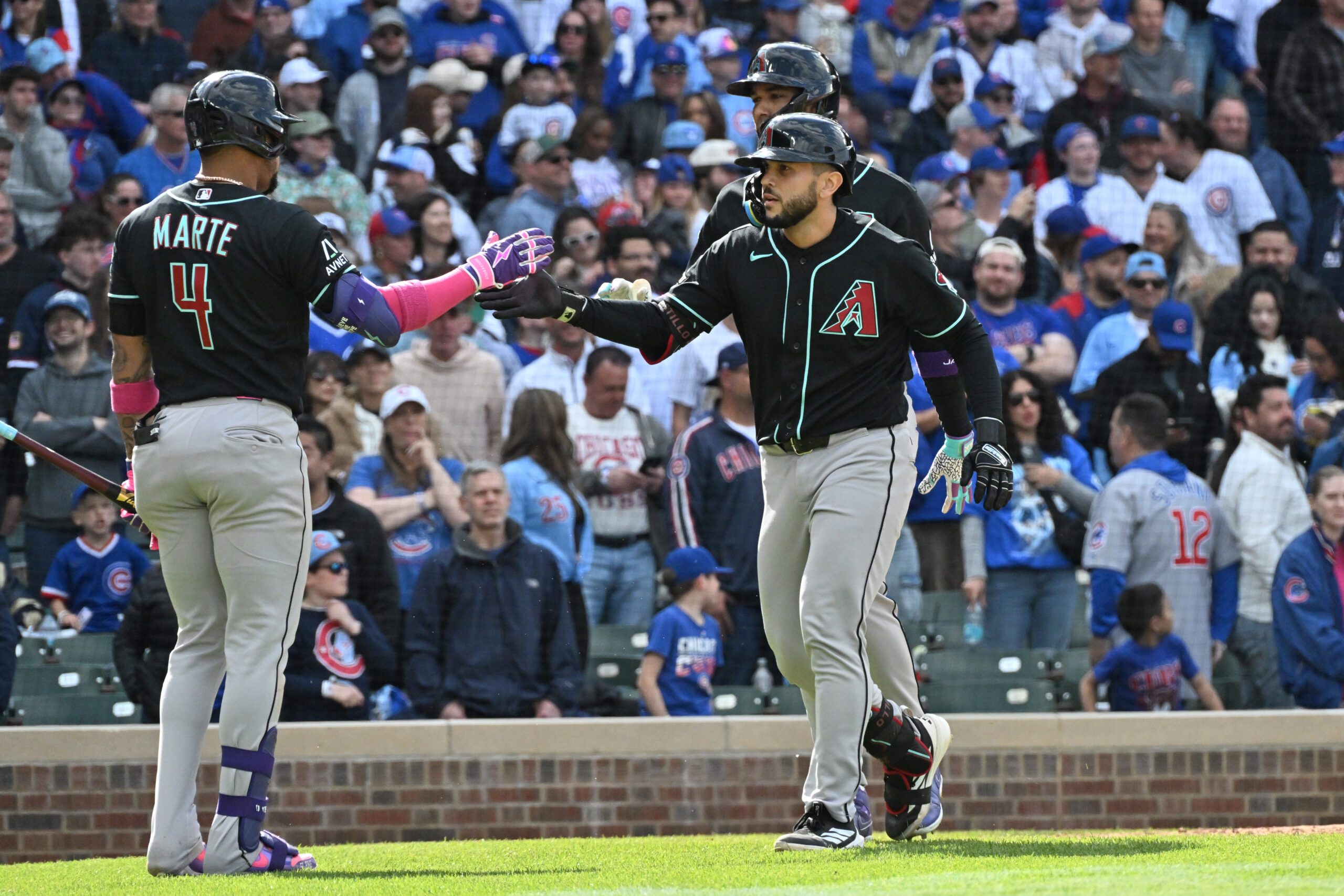 May 3, 2026; Chicago, Illinois, USA; Arizona Diamondbacks catcher Adrian Del Castillo (25) celebrates his two-run home run with second baseman Ketel Marte (4) and left fielder Lourdes Gurriel Jr. (12) against the Chicago Cubs during the ninth inning at Wrigley Field. Mandatory Credit: Patrick Gorski-Imagn Images