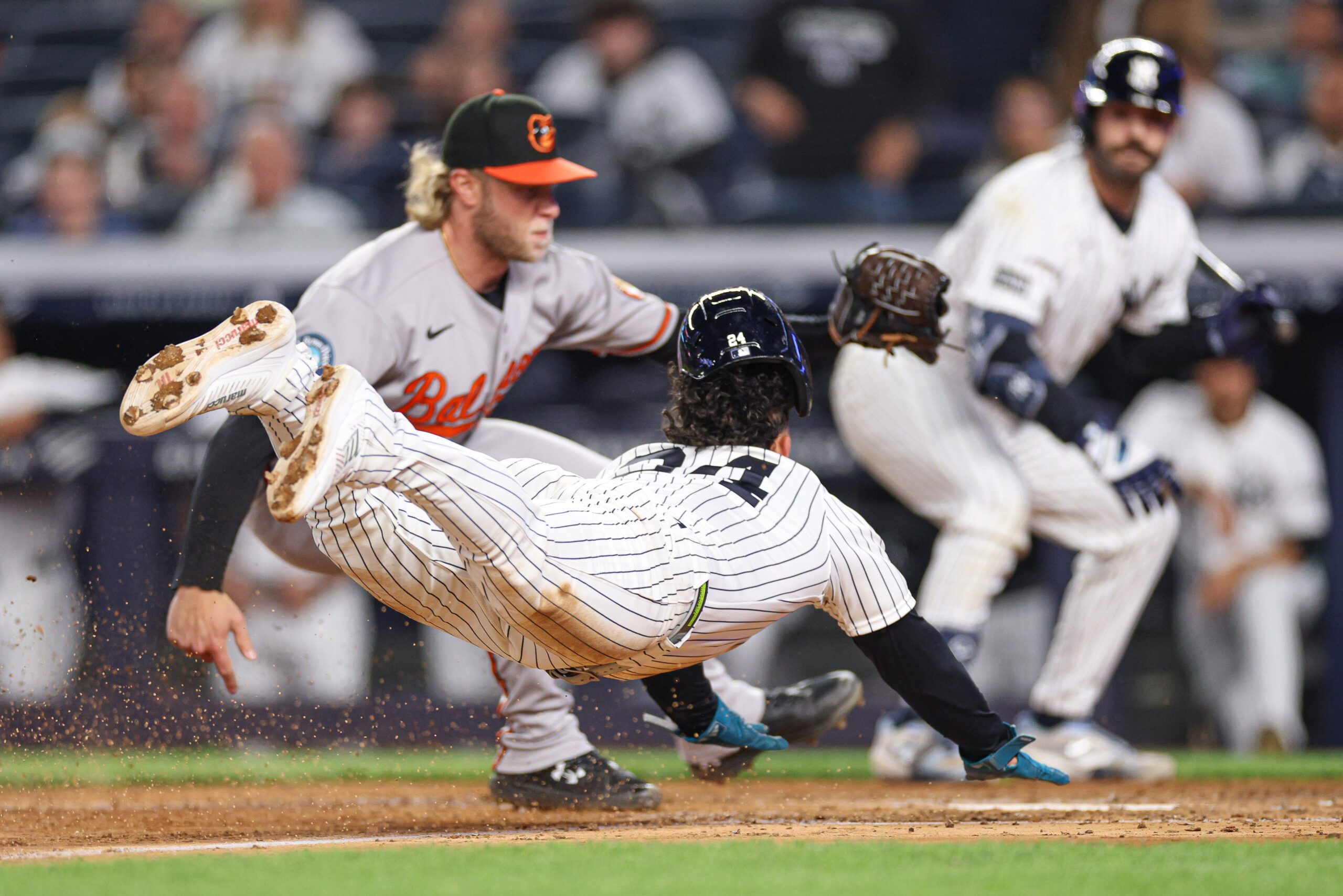 May 4, 2026; Bronx, New York, USA; New York Yankees left fielder Jasson Dominguez (24) scores a run won a wild pitch before being tagged by Baltimore Orioles pitcher Shane Baz (34) during the sixth inning at Yankee Stadium. Mandatory Credit: Vincent Carchietta-Imagn Images