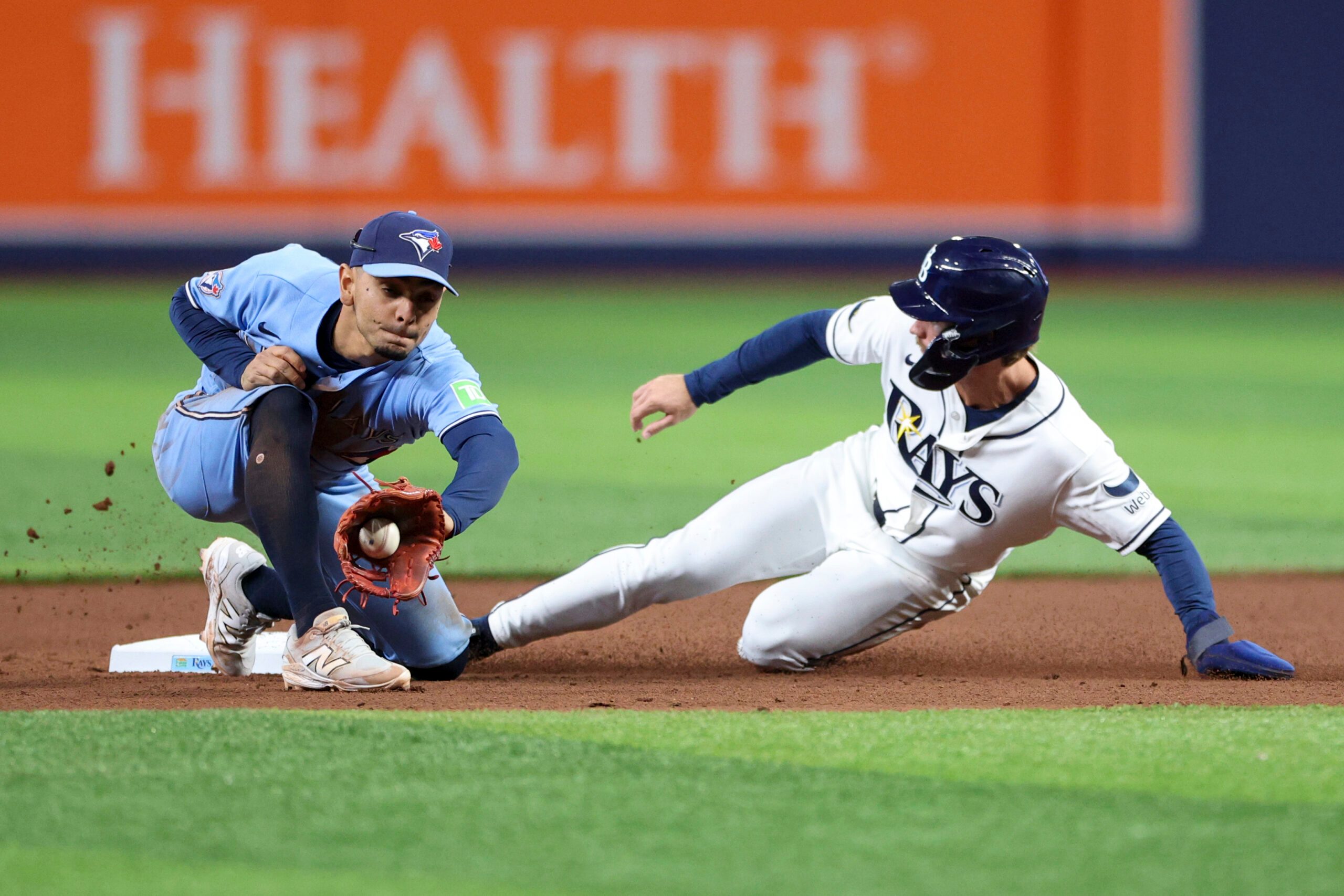 May 5, 2026; St. Petersburg, Florida, USA; Tampa Bay Rays right fielder Jonny DeLuca (21) steals second base from Toronto Blue Jays shortstop Andres Gimenez (0) in the seventh inning at Tropicana Field. Mandatory Credit: Nathan Ray Seebeck-Imagn Images