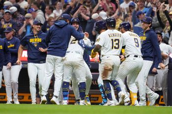 May 9, 2026; Milwaukee, Wisconsin, USA; Milwaukee Brewers pitcher Trevor Megill (29) and the rest of the Milwaukee Brewers bench swarm catcher William Contreras (24) driving in the winning run against the New York Yankees win the tenth inning at American Family Field. Mandatory Credit: Michael McLoone-Imagn Images
