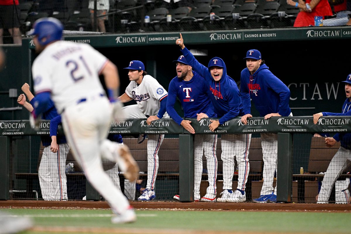 May 13, 2026; Arlington, Texas, USA; Texas Rangers first baseman Jake Burger (21) hits a single and drives in the tying run against the Arizona Diamondbacks during the ninth inning at Globe Life Field. Mandatory Credit: Jerome Miron-Imagn Images